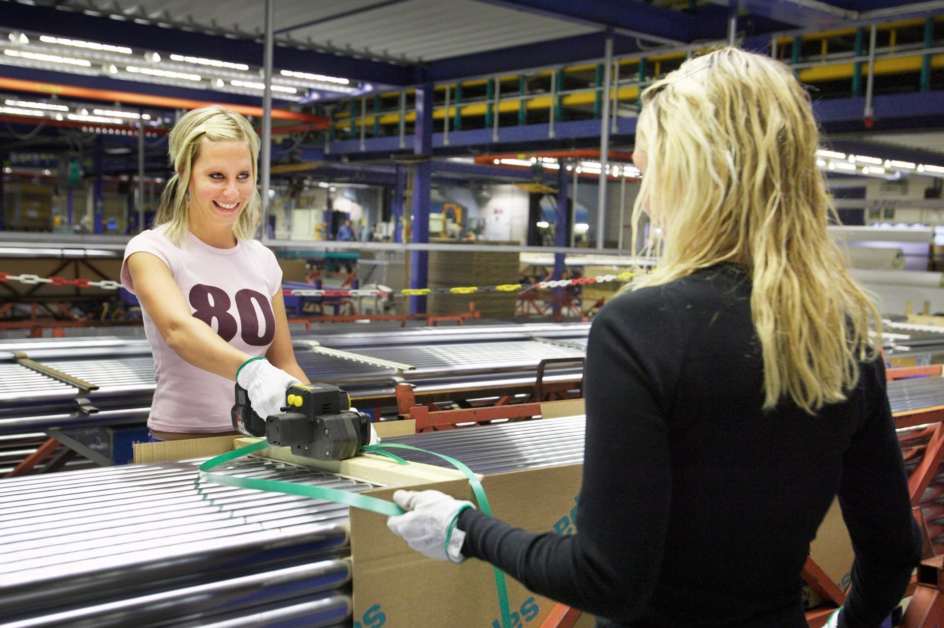 Två medarbetare packar gods i en ljus och modern industrihall (Foto: Magnus Fröderberg, Nordiska ministerrådet, CC BY 2.5 DK)
