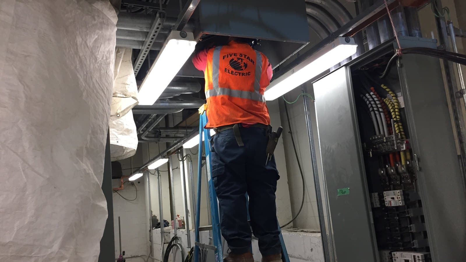 Elektriker arbetar i ett ställverksutrymme